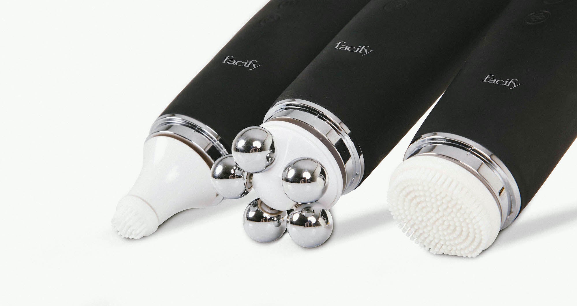 close up of the small cleansing head, iron round massager, and large cleansing head of the facify beauty wand