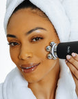 woman in spa robe and headband using the lymphatic massage attachment attachment facify beauty wand device on her face